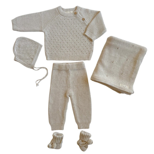 Knitted baby set with blanket, sweater, pants, hat, and booties on a white background