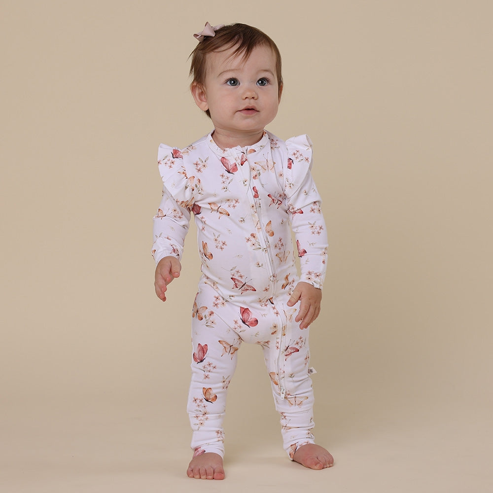 Baby wearing a floral outfit on a beige background