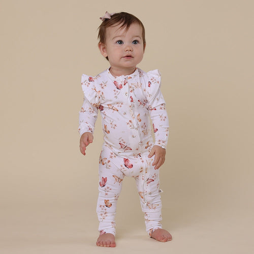 Baby wearing a floral outfit on a beige background