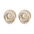 Pair of beige pacifiers with intricate lace-like design on a white background