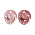 Two pink pacifiers with beaded designs on a white background