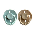 Two pacifiers, one light blue and one beige, with beaded designs on a white background.