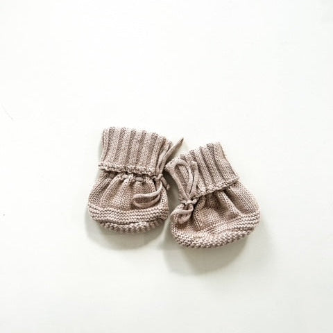 Pair of knitted baby booties on a white background