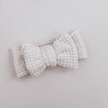 Crocheted bow headband on a light gray background