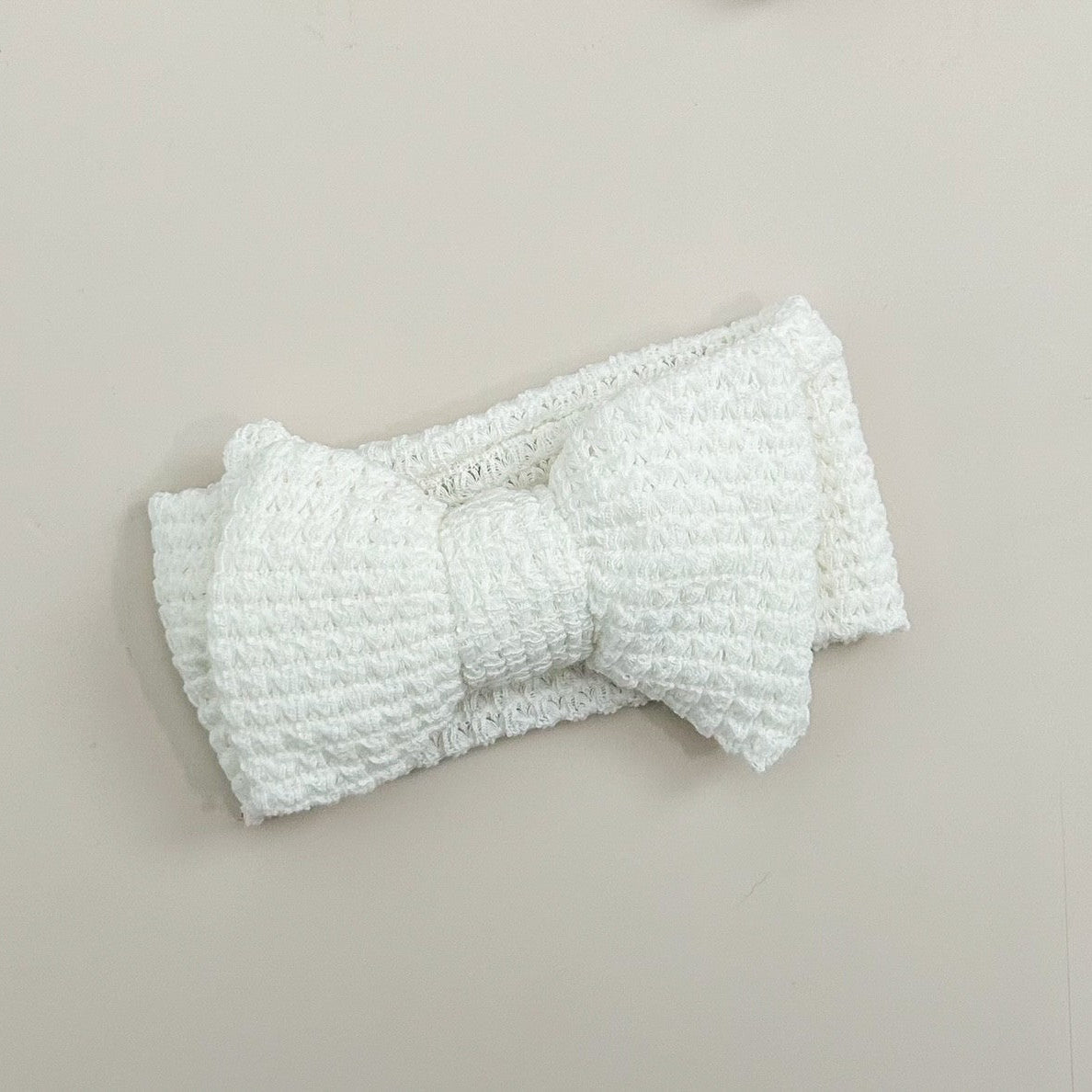 White textured headband on a beige background