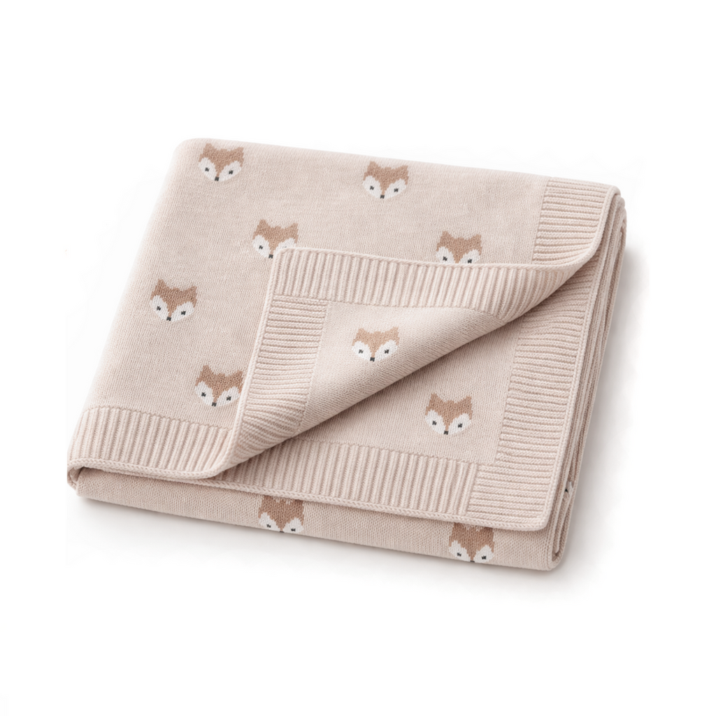Folded beige blanket with fox pattern on a white background