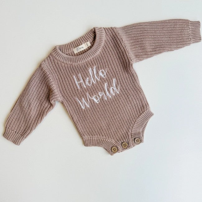 Knitted baby romper with 'Hello World' text on a white background