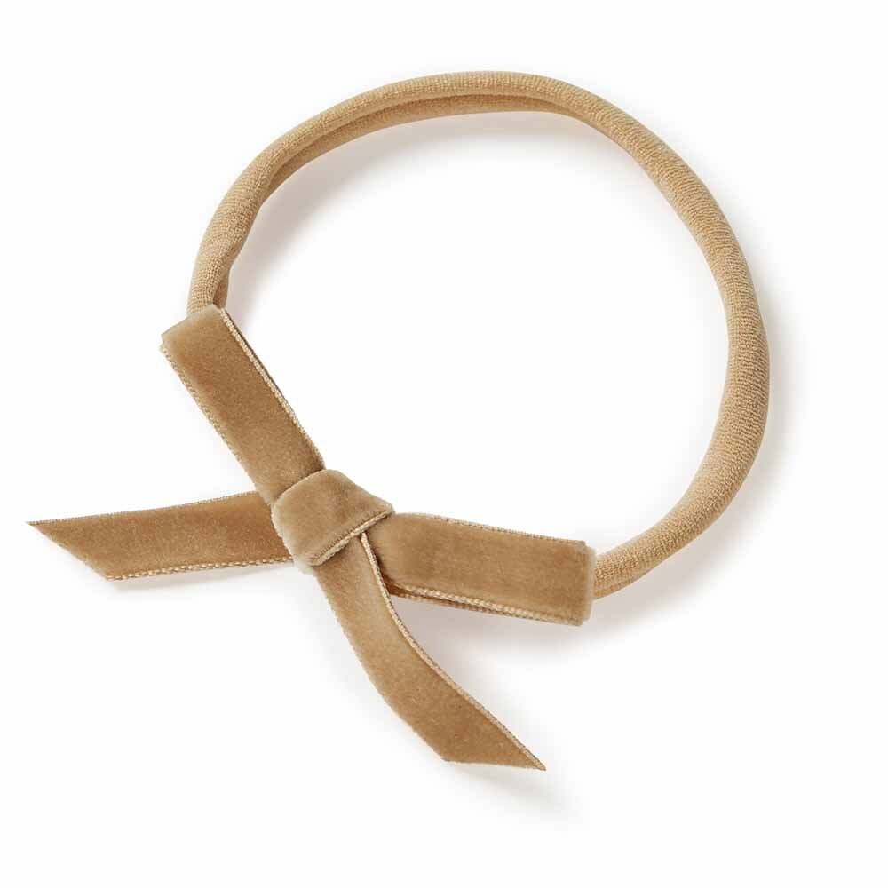 Beige velvet headband with a bow on a white background