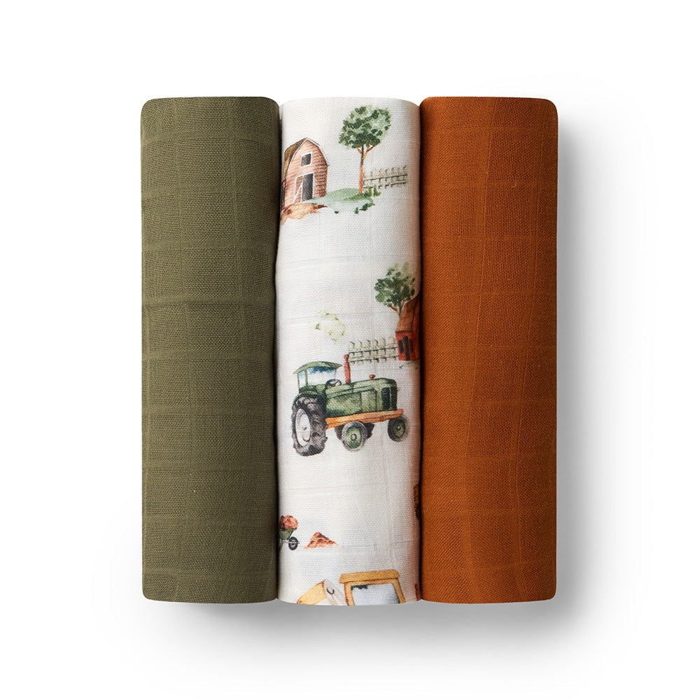 Three rolled-up muslin wraps with different patterns on a white background