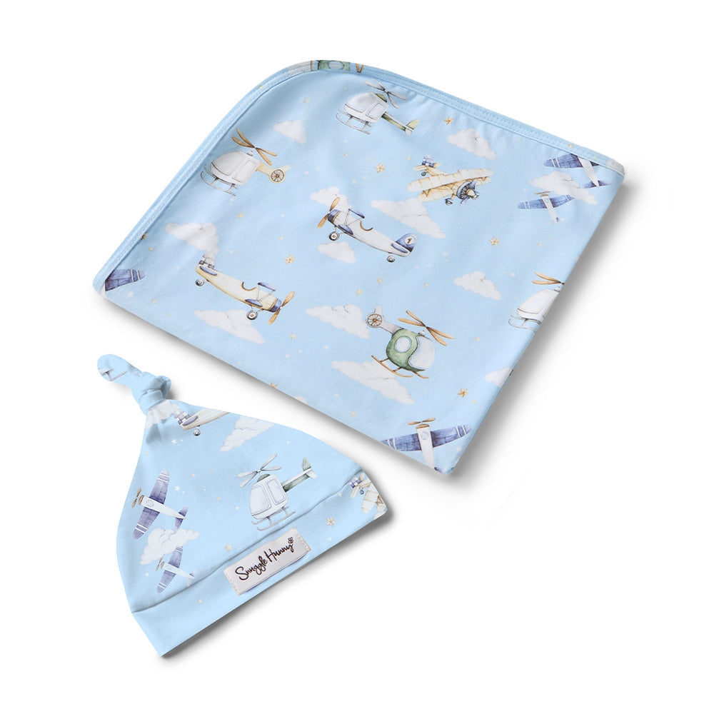 Baby hat and blanket set with airplane pattern on a light blue background